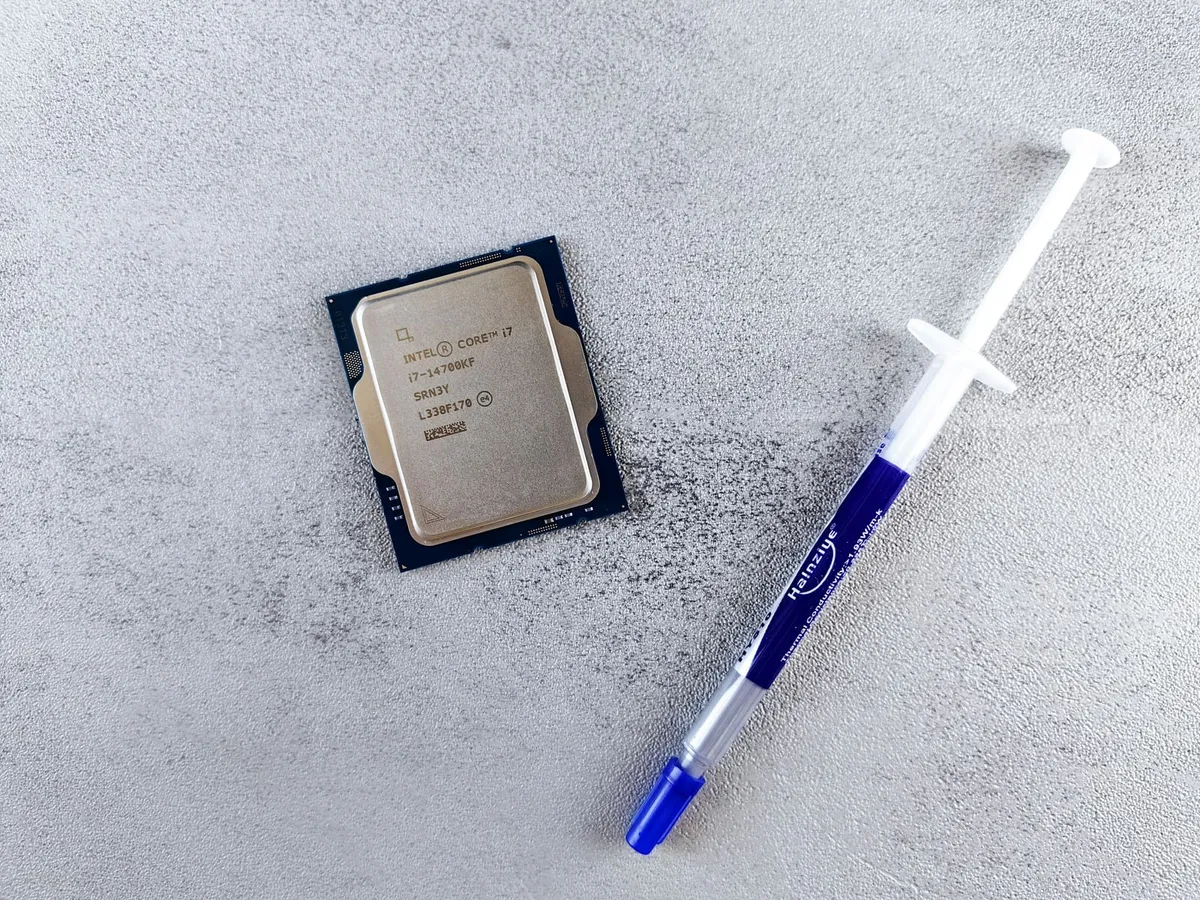 Intel Core i7 processor beside a syringe of thermal paste