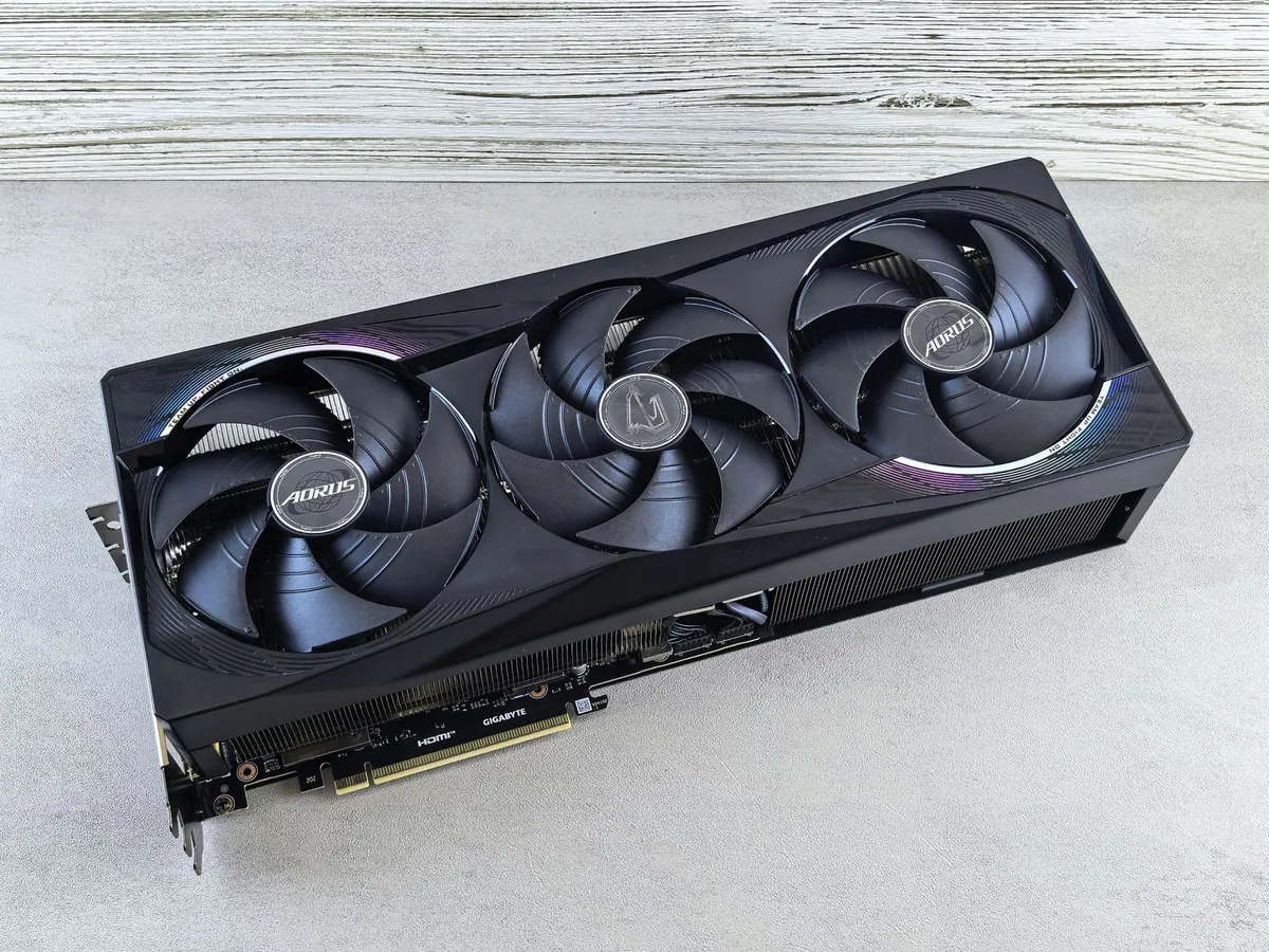 Black triple-fan graphics card on a gray surface
