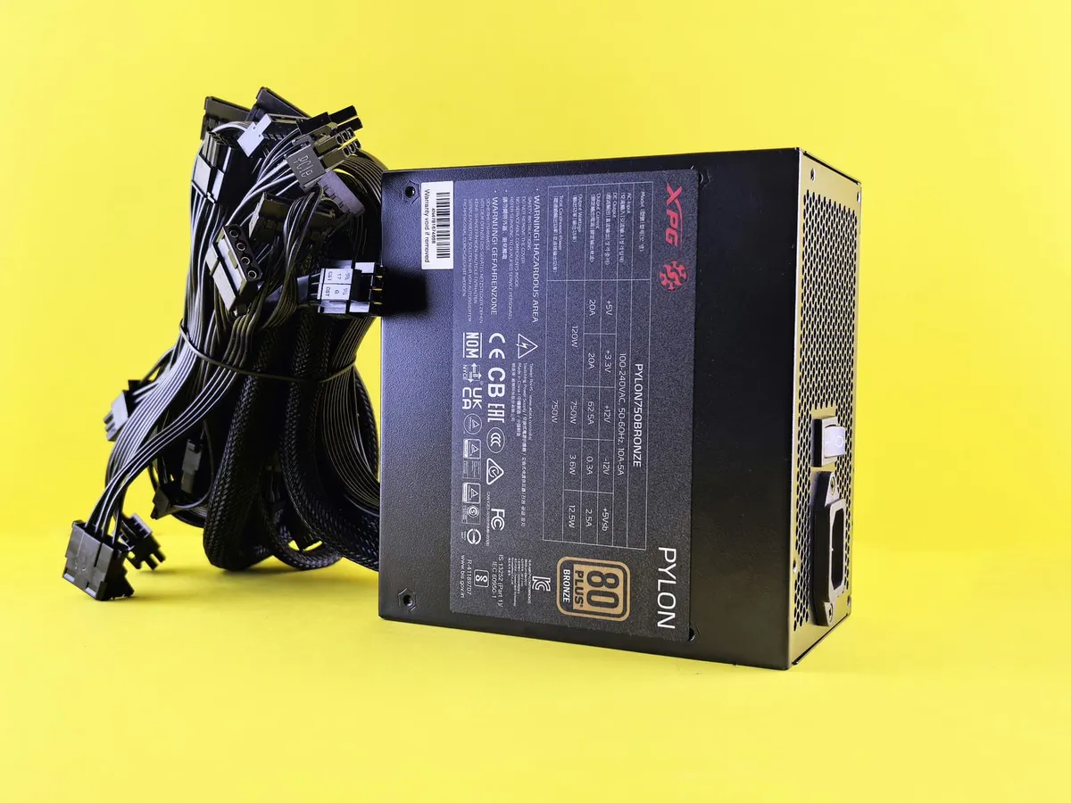 Black desktop power supply with bundled cables against a yellow background